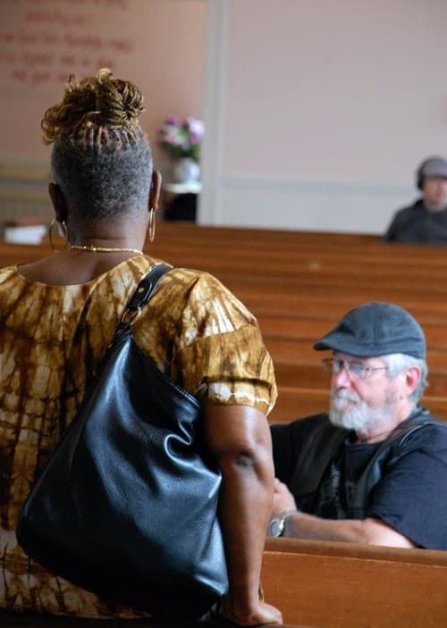 Two members of East Baptist Church talking together in the pews after a service